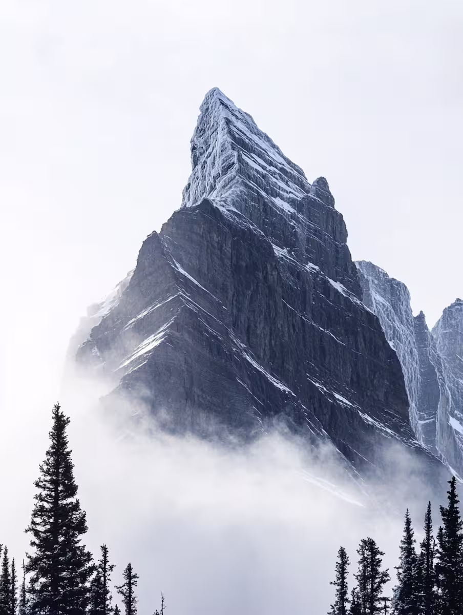 Snow-capped mountain peak with misty clouds